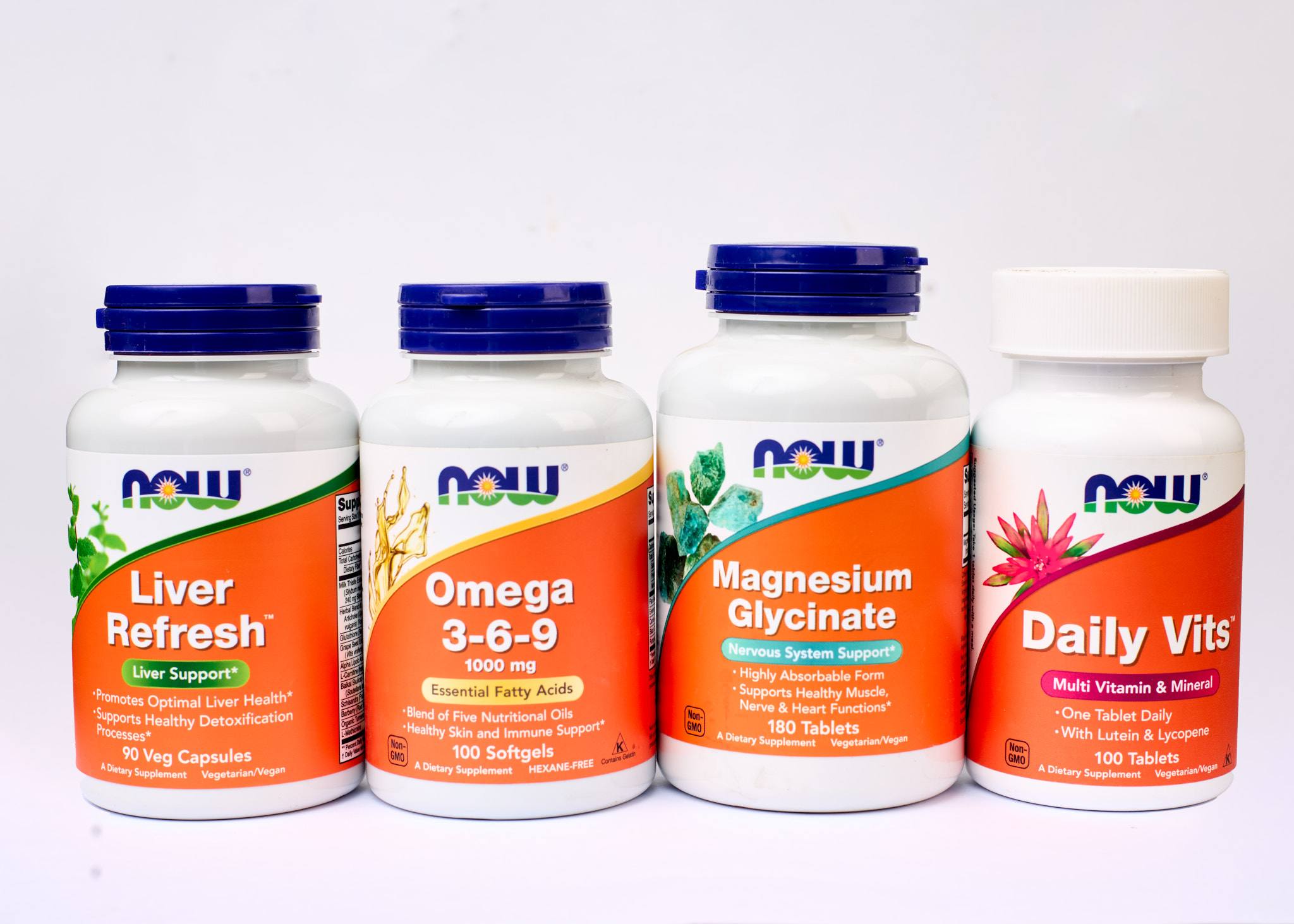 Four NOW supplement bottles grouped against a light background